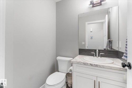 White vanity with a marble-patterned countertop, undermount sink, and chrome faucet - 3 Richmond Link, Fort Saskatchewan, AB - Indoor Photo Showing Bathroom