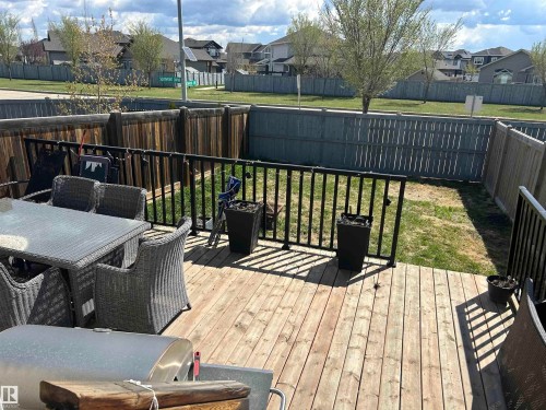 Expansive outdoor deck crafted from wood planks, featuring black metal railings and a partially fenced backyard - 3 Richmond Link, Fort Saskatchewan, AB - Outdoor With Deck Patio Veranda With Exterior