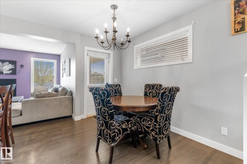 Dining area featuring wood-finish flooring, a chandelier, and a horizontal window with blinds - 3 Richmond Link, Fort Saskatchewan, AB - Indoor Photo Showing Dining Room