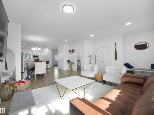 Open-concept living space featuring wood-finish flooring, recessed lighting, white walls, and a contemporary ceiling fixture - 30 Hope Cm, Spruce Grove, AB - Indoor Photo Showing Living Room