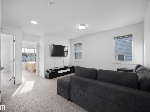 Bright interior space featuring recessed lighting, a ceiling-mounted light fixture, and two windows providing natural illumination - 30 Hope Cm, Spruce Grove, AB - Indoor Photo Showing Living Room