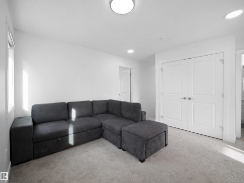 Carpeted room featuring white walls, a window with a roller shade, recessed lighting, and a flush-mount ceiling light - 30 Hope Cm, Spruce Grove, AB - Indoor Photo Showing Living Room