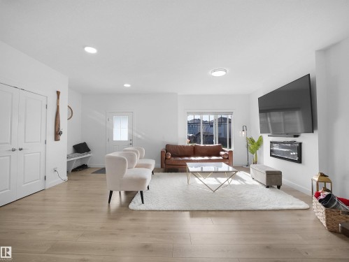 Light wood-finish flooring throughout this open-concept living space - 30 Hope Cm, Spruce Grove, AB - Indoor Photo Showing Living Room
