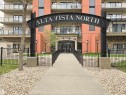 Building entrance featuring a prominent arched sign, stone facade elements, and a concrete pathway with black metal railings - 707 10319 111 Street Nw, Edmonton, AB  - Outdoor With Balcony With Facade 