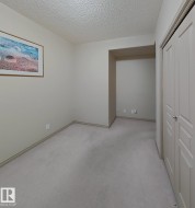 Carpeted room with neutral wall tones and a built-in alcove - 