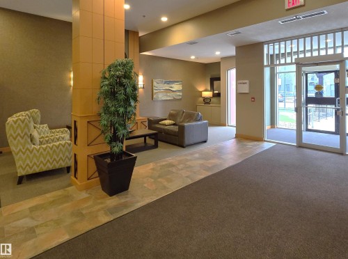 Lobby area featuring mixed flooring with carpet and stone-look tiles - 707 10319 111 Street Nw, Edmonton, AB - Indoor Photo Showing Other Room