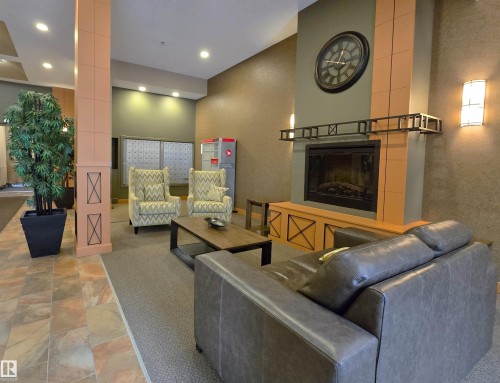 Inviting common area featuring a central fireplace with decorative mantel, recessed lighting, and wall-mounted sconces - 707 10319 111 Street Nw, Edmonton, AB - Indoor With Fireplace
