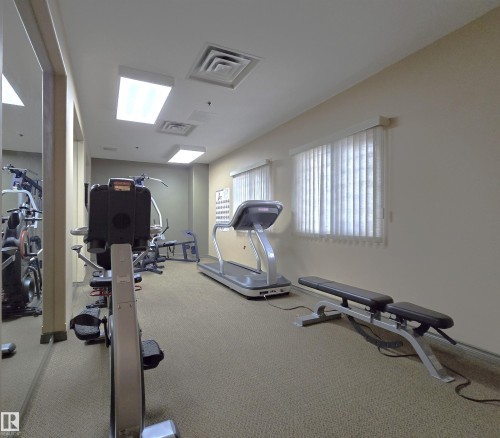 Dedicated fitness room featuring recessed lighting, light-colored walls, carpet flooring, and multiple windows with blinds - 707 10319 111 Street Nw, Edmonton, AB - Indoor Photo Showing Gym Room
