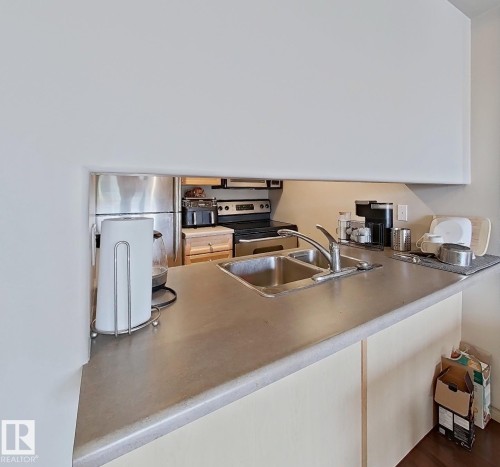 Kitchen pass-through featuring an undermount double-basin stainless steel sink with a gooseneck faucet - 707 10319 111 Street Nw, Edmonton, AB - Indoor Photo Showing Kitchen
