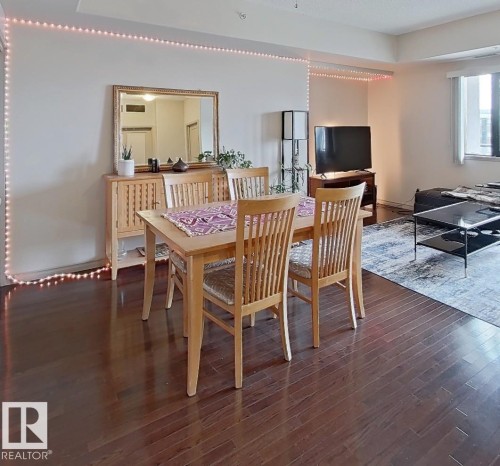 Dining area featuring wood-finish flooring, a neutral wall color, and a built-in wall niche - 707 10319 111 Street Nw, Edmonton, AB - Indoor Photo Showing Dining Room