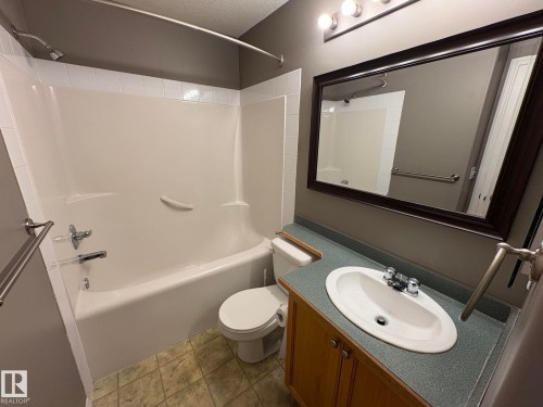 Full bathroom with a white bathtub and shower combination, featuring a chrome shower head and faucet - 138 9525 162 Avenue, Edmonton, AB 