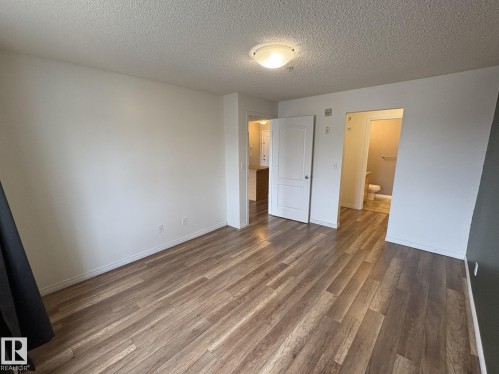 Spacious interior with wood-finish flooring, white baseboards, and a neutral color palette - 138 9525 162 Avenue, Edmonton, AB 