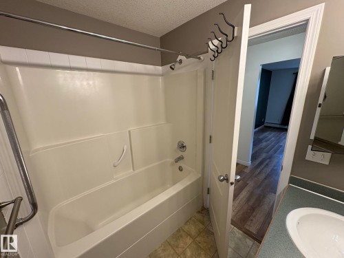 Tub and shower combination with chrome fixtures and integrated grab bar - 138 9525 162 Avenue, Edmonton, AB 