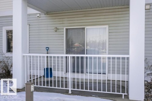 Covered patio featuring a white metal railing and a sliding glass door with a screen - 138 9525 162 Avenue, Edmonton, AB 