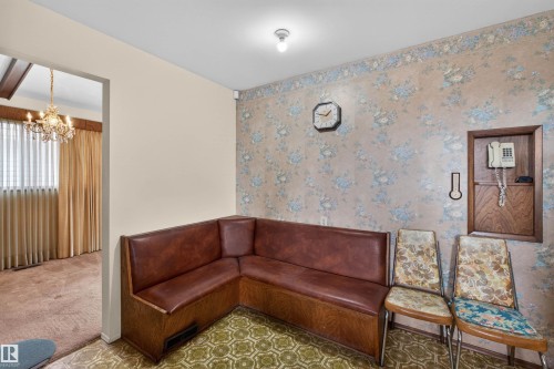 Corner seating with brown upholstery, patterned green floor covering, and floral wallpaper - 8407 150 Avenue, Edmonton, AB - Indoor Photo Showing Other Room