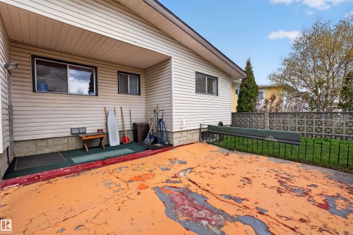 Exterior featuring horizontal siding, a covered patio area, and a fenced yard with a decorative concrete block wall - 8407 150 Avenue, Edmonton, AB - Outdoor With Exterior