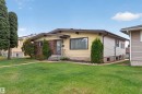 Exterior featuring a brick facade, yellow siding, and a gabled roofline - 8407 150 Avenue, Edmonton, AB  - Outdoor 