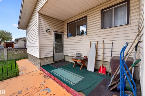 Covered patio area featuring vinyl siding and a security screen door - 8407 150 Avenue, Edmonton, AB - Outdoor With Exterior