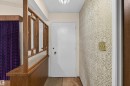 Entryway featuring a white door, textured wallpaper, and an ornate wood-and-glass divider - 8407 150 Avenue, Edmonton, AB  - Indoor Photo Showing Other Room 