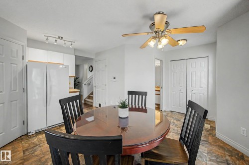 Dining area featuring a ceiling fan with integrated lighting, wood-finish flooring, and white walls - 16211 55A Street, Edmonton, AB - Indoor Photo Showing Dining Room