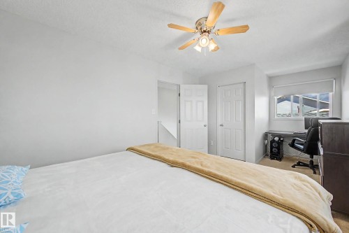 Light-filled room featuring a ceiling fan with wood-finish blades and integrated lighting - 16211 55A Street, Edmonton, AB - Indoor Photo Showing Bedroom