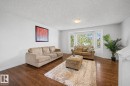 Living space featuring wood-finish flooring, crisp white walls, and a prominent bay window - 16211 55A Street, Edmonton, AB  - Indoor Photo Showing Living Room 