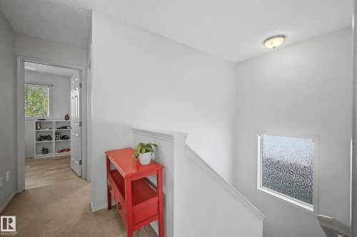 Stairwell featuring a white painted railing, textured window, and overhead lighting - 16211 55A Street, Edmonton, AB - Indoor Photo Showing Other Room