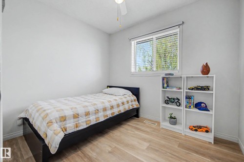 Room featuring wood-finish flooring, a window with blinds, a ceiling fan, and white walls - 16211 55A Street, Edmonton, AB - Indoor Photo Showing Bedroom