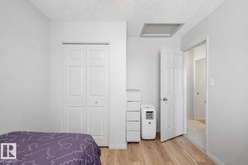 Bedroom featuring light wood-finish flooring, white walls, and a white bi-fold closet door - 16211 55A Street, Edmonton, AB - Indoor Photo Showing Bedroom