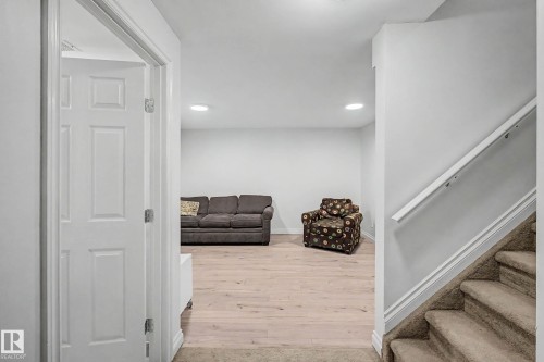Finished lower level with recessed lighting, light wood-finish flooring, and a six-panel door - 16211 55A Street, Edmonton, AB - Indoor Photo Showing Other Room