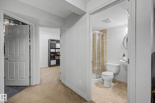 Well-appointed bathroom featuring a corner shower with tiled surround, pedestal sink, and tiled flooring - 16211 55A Street, Edmonton, AB - Indoor Photo Showing Bathroom