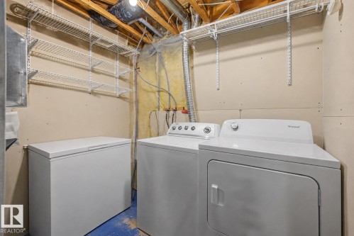 Dedicated utility area featuring exposed ceiling joists, drywall-finished walls, and blue-painted concrete flooring - 16211 55A Street, Edmonton, AB - Indoor Photo Showing Laundry Room