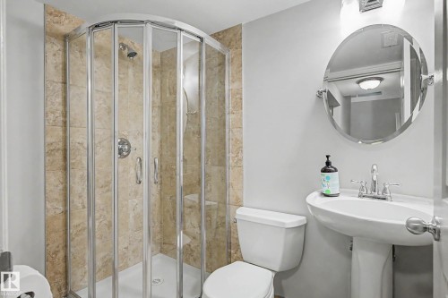 Bathroom featuring a corner shower with glass enclosure and tiled walls - 16211 55A Street, Edmonton, AB - Indoor Photo Showing Bathroom
