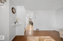 Warm wood-finish flooring complements light wall tones throughout this interior space - 16211 55A Street, Edmonton, AB  - Indoor Photo Showing Other Room 