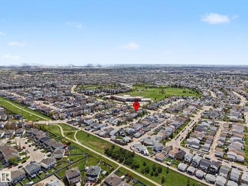 Aerial perspective showcasing a residential neighborhood with numerous detached homes, a large green space, and a community building - 16211 55A Street, Edmonton, AB - Outdoor With View