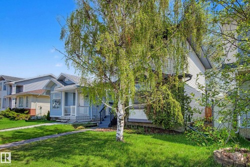 Light blue siding exterior featuring a covered porch with white railings and steps - 16211 55A Street, Edmonton, AB - Outdoor