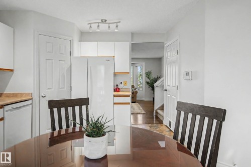 Kitchen area featuring white cabinetry, light wood-finish countertops, and track lighting - 16211 55A Street, Edmonton, AB - Indoor Photo Showing Dining Room