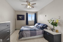 Bedroom featuring light neutral wall paint, a window with dark curtains, and a ceiling fan with integrated lighting - 