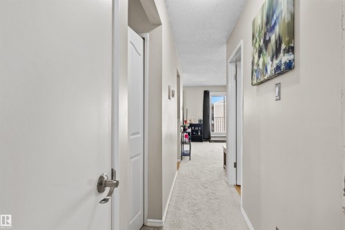 Interior hallway featuring light-colored carpet, painted walls, and white trim - 6 3803 76 Street, Edmonton, AB - Indoor Photo Showing Other Room