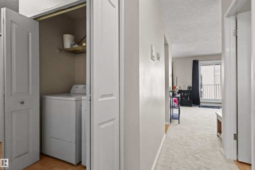 In-unit laundry closet with bi-fold doors and a built-in shelf - 6 3803 76 Street, Edmonton, AB - Indoor Photo Showing Laundry Room