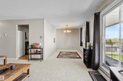 Spacious interior featuring neutral wall tones, textured ceiling, and light-toned carpeting - 