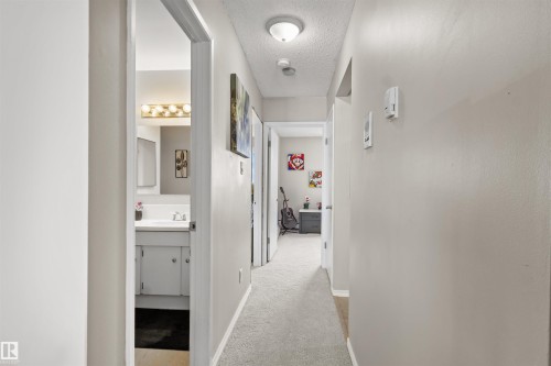 Carpeted hallway with light neutral wall paint - 6 3803 76 Street, Edmonton, AB - Indoor