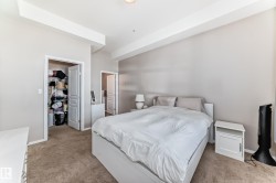 Carpeted bedroom featuring neutral wall paint, a built-in closet with shelving, and high ceilings - 