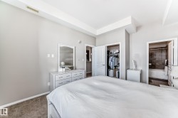 Carpeted bedroom with neutral wall tones and a tray ceiling - 