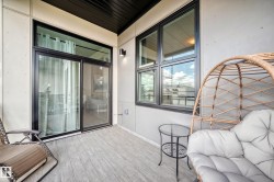Outdoor balcony featuring wood-finish flooring, a dark ceiling, and light-colored walls - 