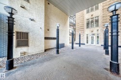Exterior walkway featuring concrete paving and a series of black lampposts - 