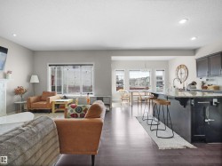 Open-concept living space featuring rich wood-finish flooring throughout - 