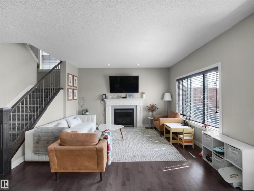 Living area featuring dark wood-finish flooring and light gray painted walls - 3247 15 Avenue Nw, Edmonton, AB 
