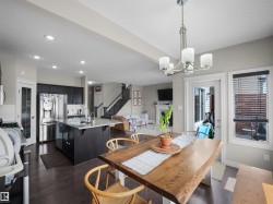Open-concept living space featuring a kitchen with dark cabinetry, stainless steel appliances, a center island with a granite-style countertop, and recessed lighting - 