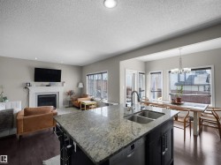 Kitchen island featuring a granite countertop and an undermount double-basin sink with a gooseneck faucet - 